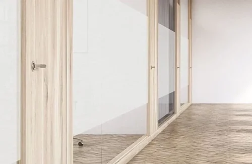 Glastrennwand mit halbtransparentem Hafttextil für diskreten Sichtschutz im Büro