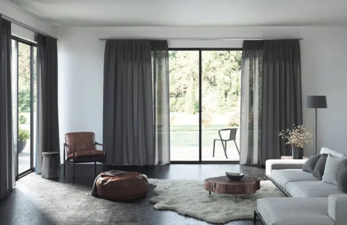 Wohnzimmer mit bodentiefen Fenstern und dunkelgrauen Vorhängen